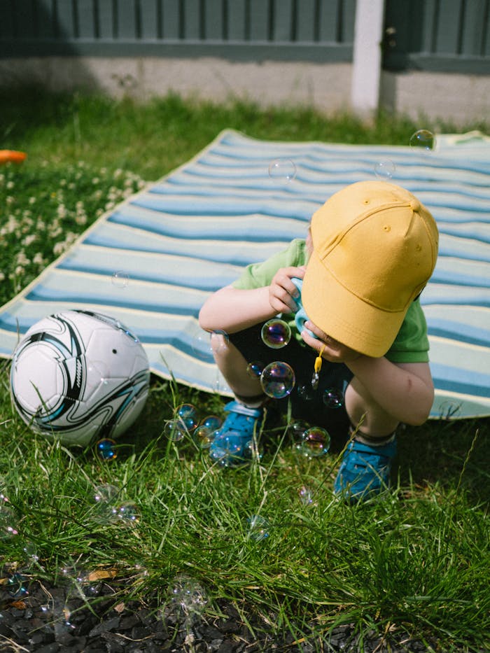 A young boy playing with bubbles on a sunny summer day, capturing a moment of pure joy and playfulness.